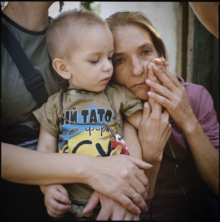 Olha Hrynyk with her nephew, Tymofii Tsvetkov, in the Poltava region. Tymofii’s T-shirt reads, “My father serves in the Armed Forces of Ukraine.” Since the full-scale Russian invasion, Olha’s husband, Mykola, has been conscripted into the Ukrainian army, along with all the men in their extended family. 2024. (Image: Anastasia Taylor-Lind)