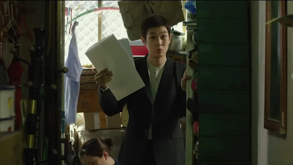 Choi Woo-shik holding up papers in Parasite