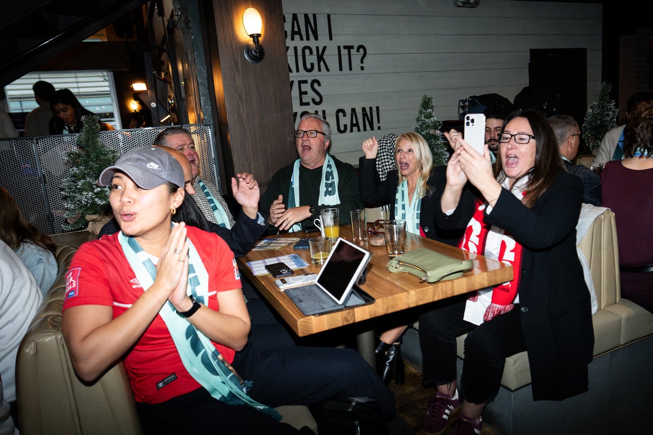A group of fans watch TV.