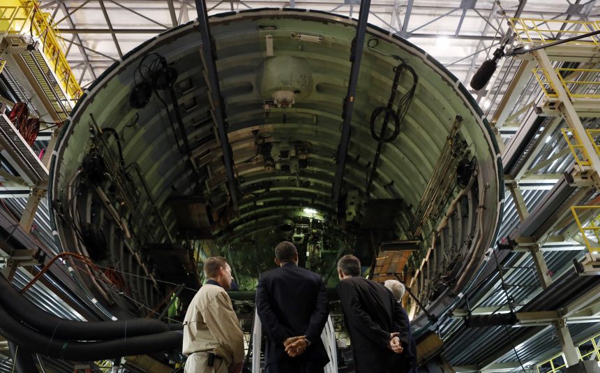 Former US President Barack Obama looks at the bow sections of the USS John Warner before speaking at Newport News Shipbuilding in Newport News, Virginia