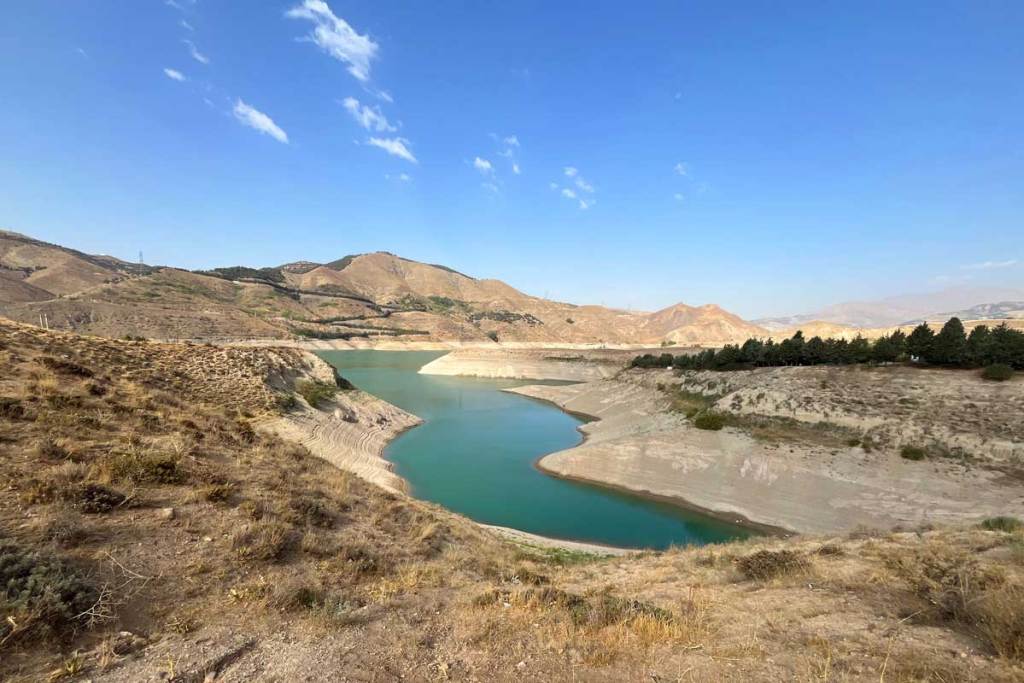 A photo of a lake created a by a dam where the lake levels are extremely low