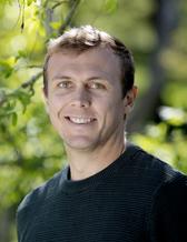 Portrait image of Marcel du Plessis. Greenery in the background.