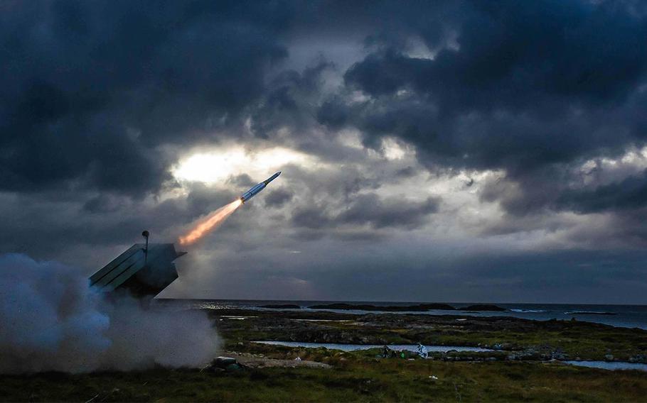 A missile fires from a ground-based launcher.