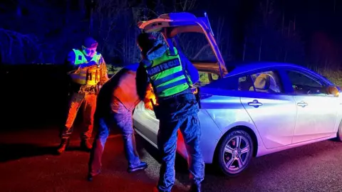 Police check vehicles on the roads in Lithuania after dark