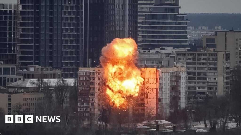 A firefighter works at a residential building that is ablaze