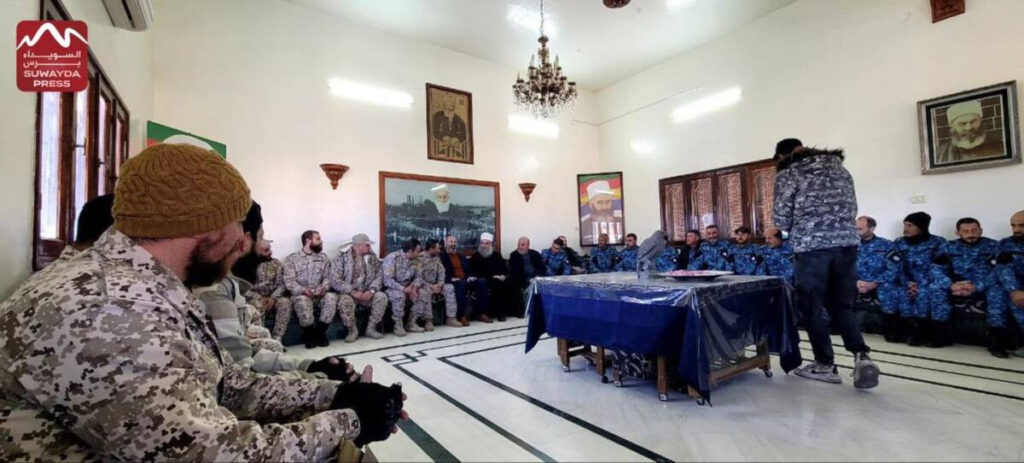 Suwayda stands at a crossroads, one year after Assad’s fall Syrian Druze religious leader Sheikh Hikmat al-Hijri (center, in turban) meets with leaders of the Suwayda National Guard militia and its affiliated Internal Security Forces at the headquarters of the Druze spiritual presidency in the Suwayda countryside town of Qanawat, 17/12/2025 (Suwayda Press)