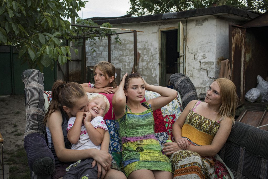 (L-R) Oleksandra Mountyan, Myroslava Hrynyk, Olha Grinik, Viktoriia Mountyan and Valentyna Mountyan—all members of an extended family—hanging out in the backyard of Olha’s house, located 50 meters from a Ukrainian military position in old Avdiivka, 2018. From the series 5K from the Frontline. (Image: Anastasia Taylor-Lind)
