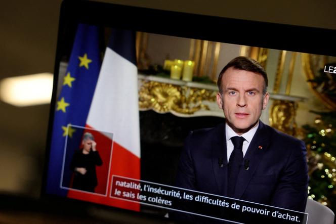 French President Emmanuel Macron appears on a screen as he delivers his New Year's speech at the Elysee Palace in Paris, France, December 31, 2025.