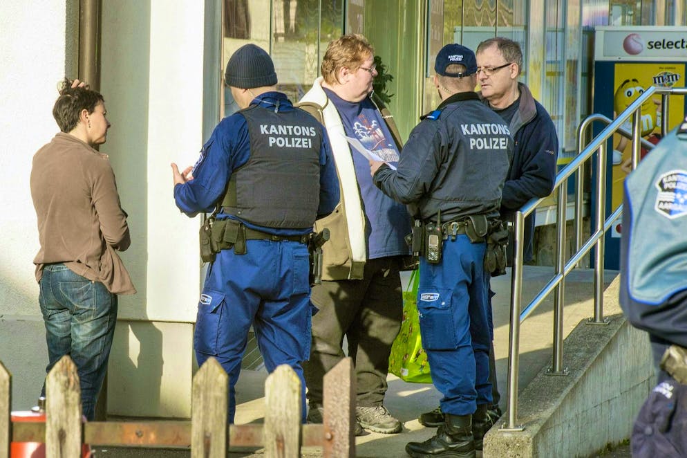 The cantonal police immediately launched a major search operation. The picture shows cantonal police officers talking to the people of Rupperswil AG.