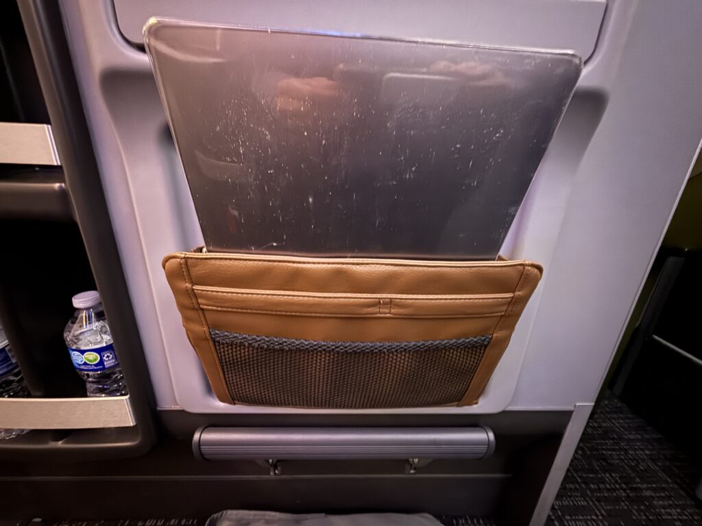 A laptop is stowed away in the leather pouch provided on the seat.