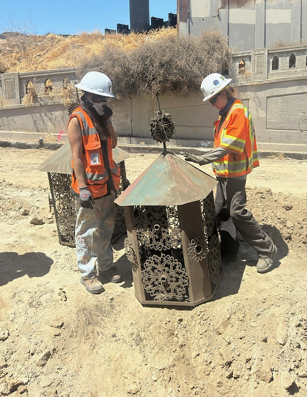 two people standing over a street lamp