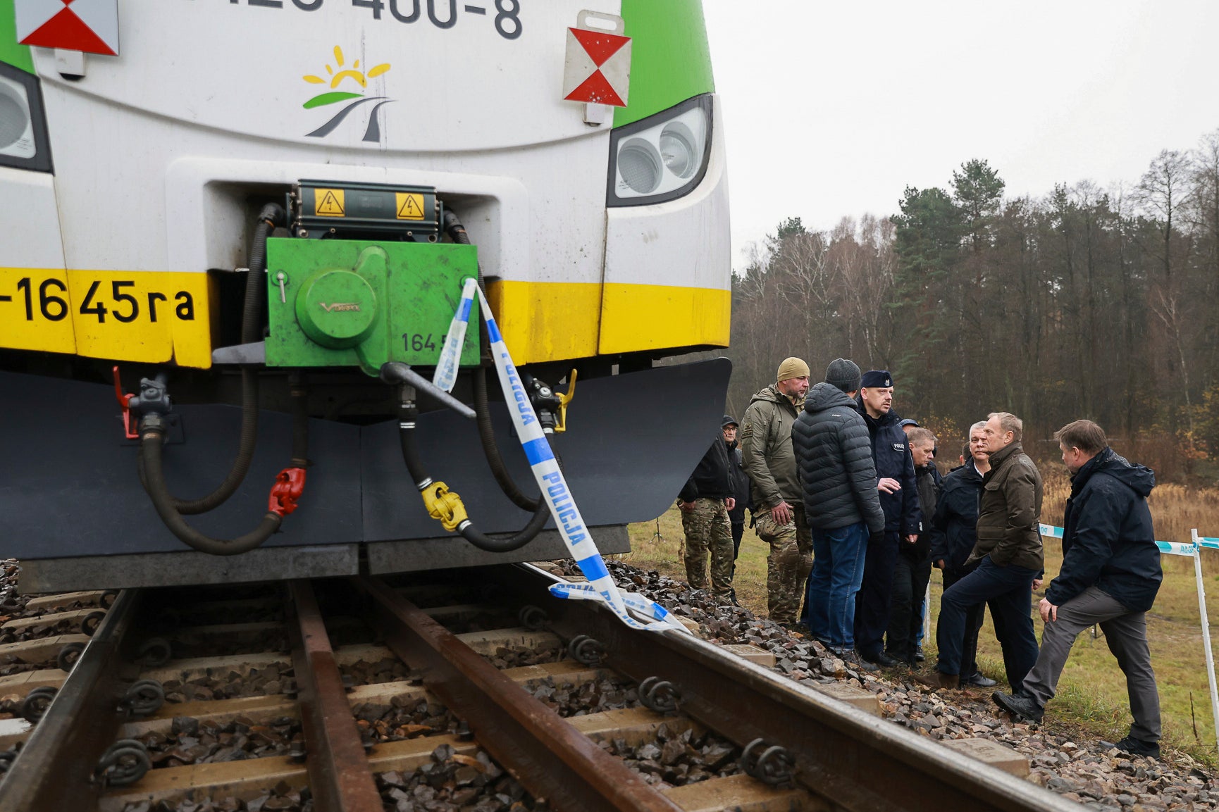 Polish Prime Minister Donald Tusk, second right, visits the sabotaged rail line near Mika, Poland