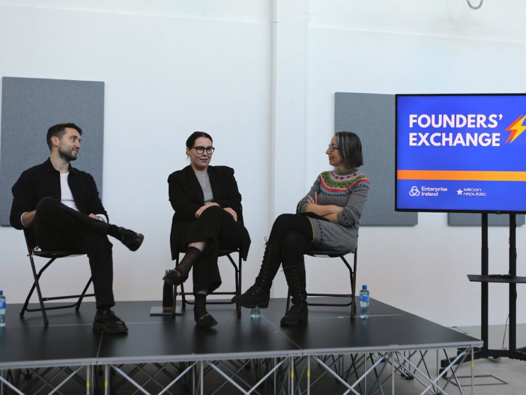 One man and two women sitting on a stage at a panel discussion.