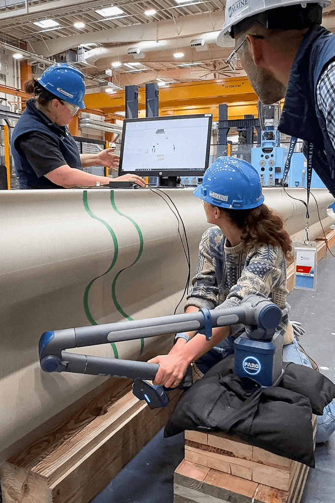 A photo of three people working with a 3D printed item