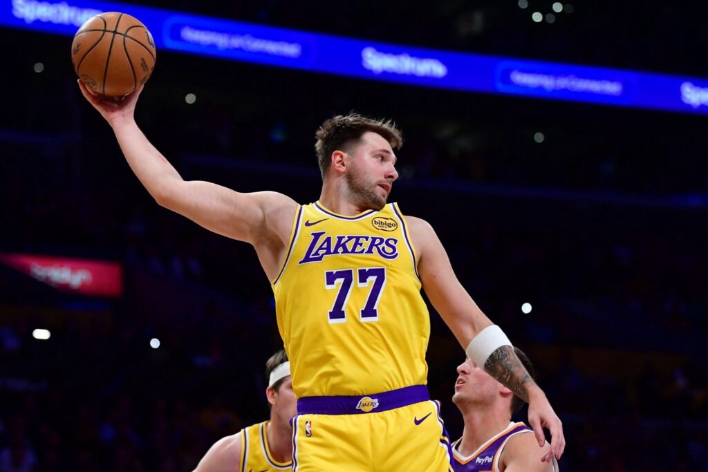 Dec 1, 2025; Los Angeles, California, USA; Los Angeles Lakers guard Luka Doncic (77) gets the rebound against the against the Phoenix Suns during the first half at Crypto.com Arena. Mandatory Credit: Gary A. Vasquez-Imagn Images