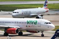 American Airlines and Viva Aerobus planes pass Terminal E at DFW International Airport on...