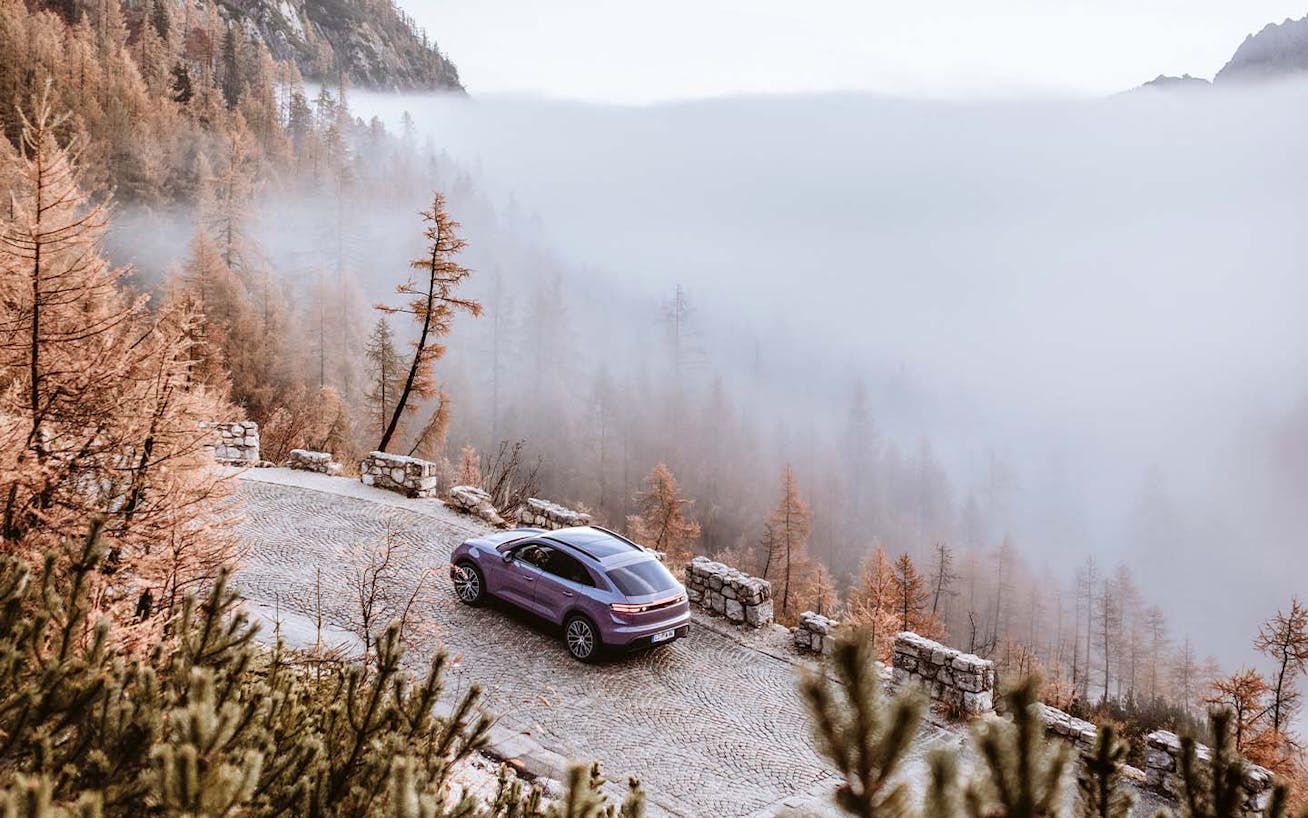 Porsche Macan Electric on Slovenian pass with misty backdrop on Porsche Travel Experience_new