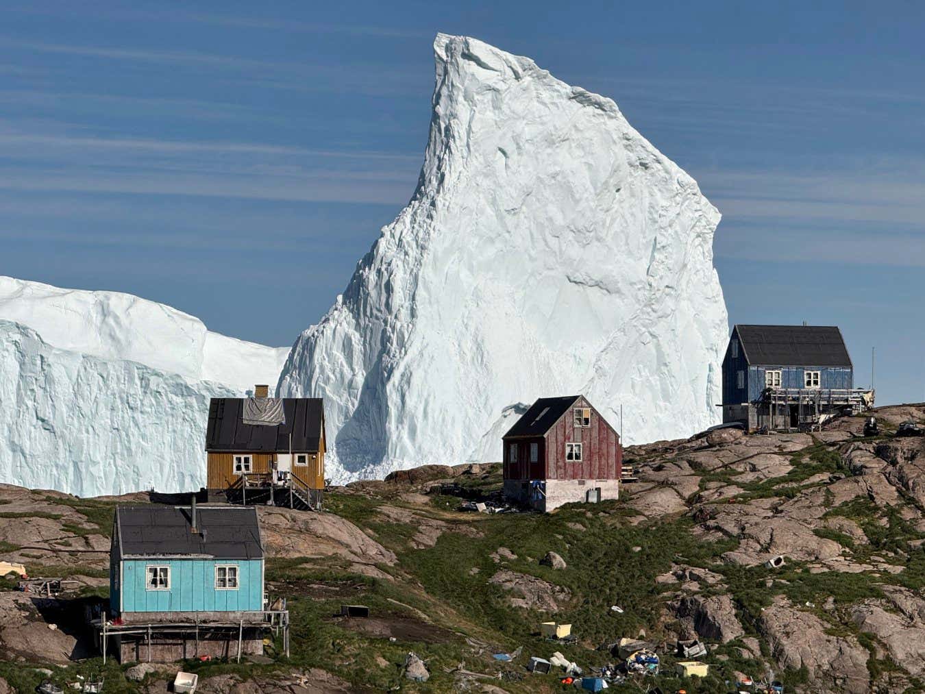Incredible images show a huge iceberg drifting dangerously close to the shore in Greenland this week. The towering structure has been edging closer to a harbour in Innaarsuit, where local authorities have issued warnings to the public. It is now near the Royal Greenland fish factory and the local food store, where people are being advised to take care when visiting.