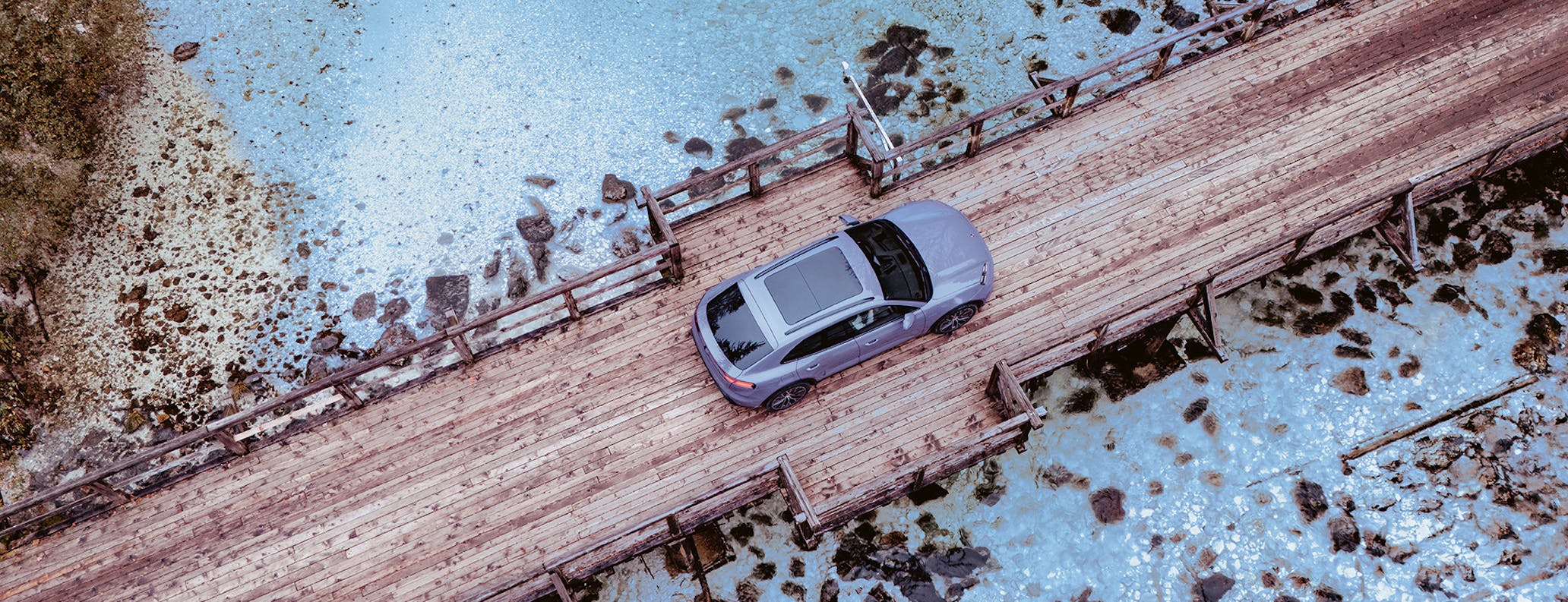 Porsche Macan Electric in Provence paint on wooden bridge in Slovenia