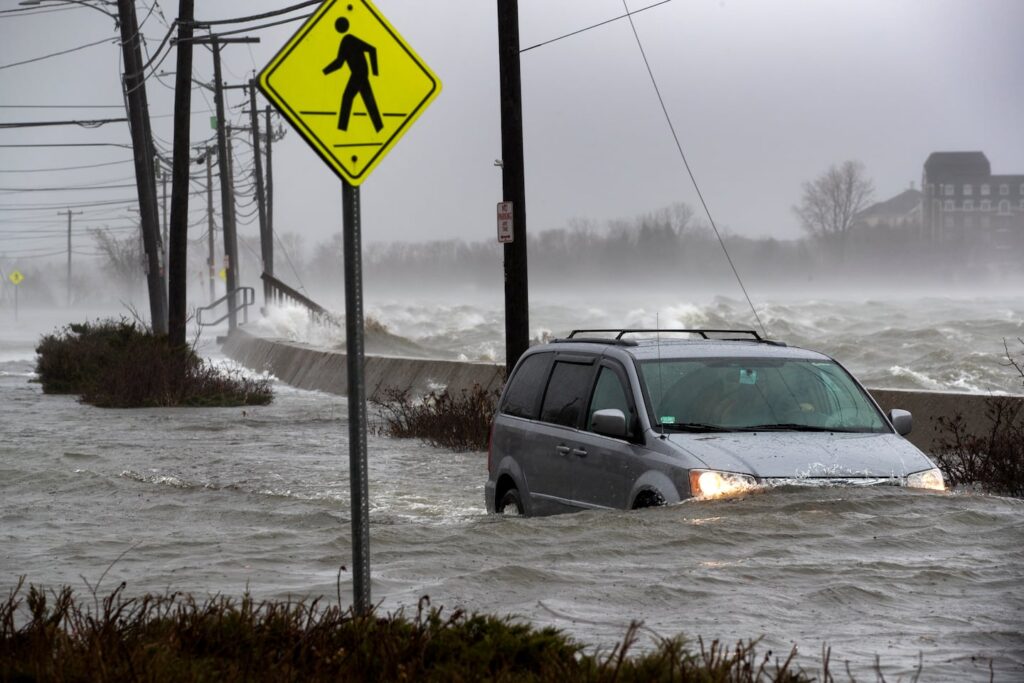 A van traveled on the flooded East Squantum Street in Quincy during a storm in 2018.