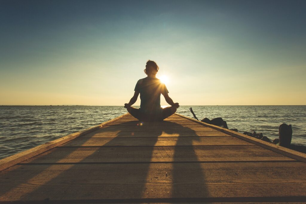 Central Shenandoah Health District encourages a new, healthier you in 2026 A person meditating on a pier near water.