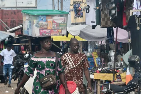 AFP via Getty Images People in a market in the Togolese capital.