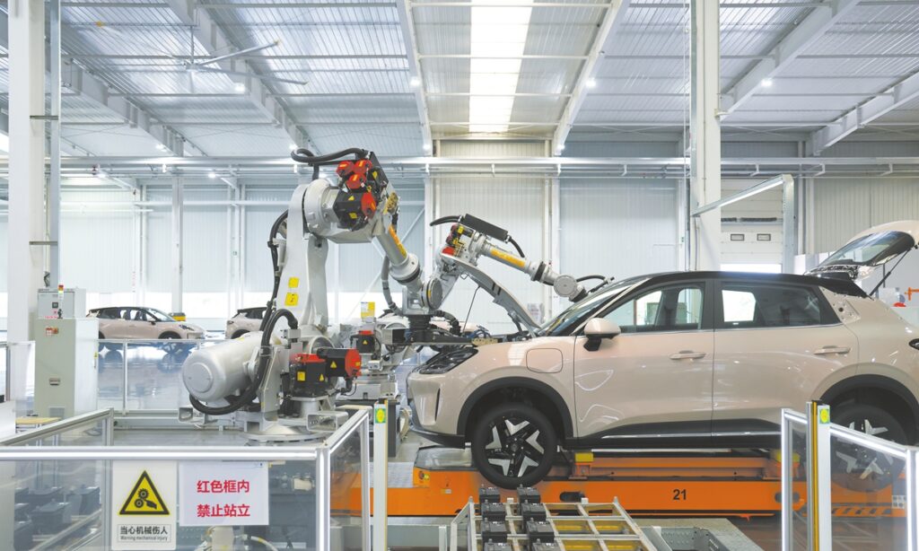 Robotic arms assemble vehicles on an automated production line at SAIC-GM-Wuling