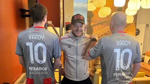 Supplied Two men with their backs turned with Vardy and the number 10 on the back with Jamie Vardy in the middle