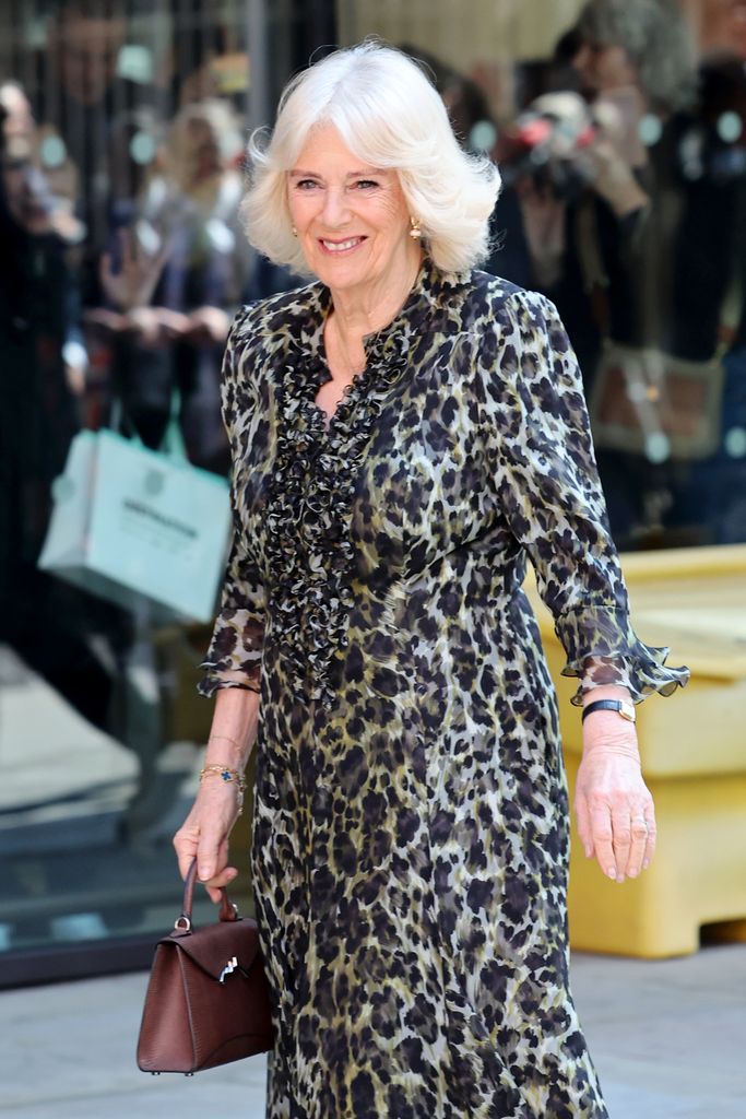 queen camilla smiling in a leopard print dress