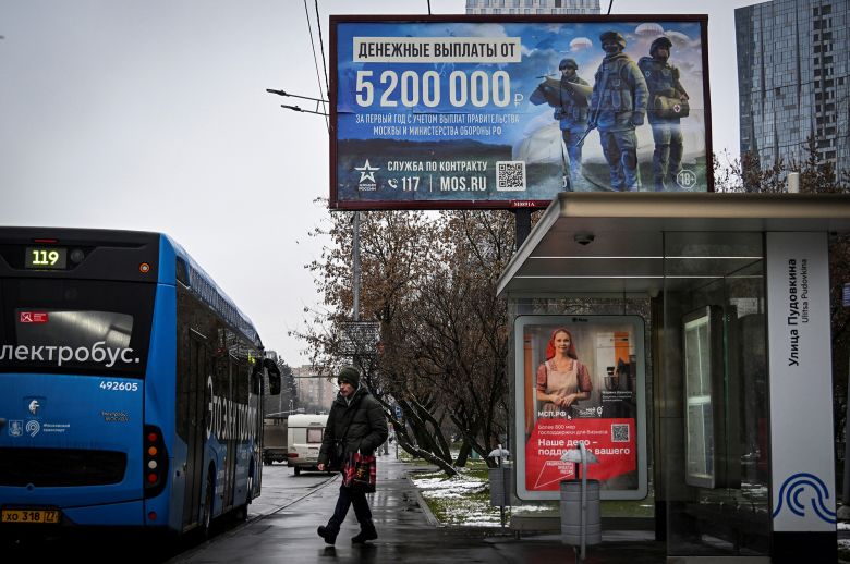 A man walks past a billboard in western Moscow promoting army service and offering 