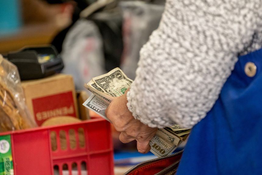A shopper holds US banknotes in San Francisco, California, on December 15.