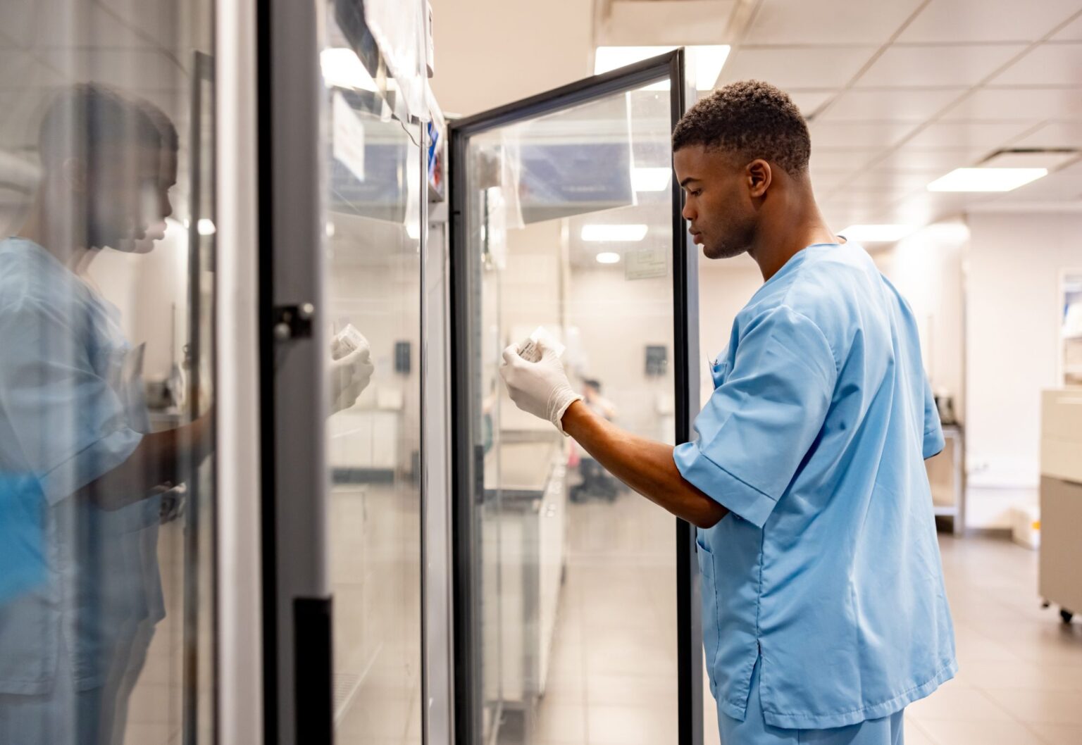 African American healthcare worker working at the laboratory and taking medicines out of a fridge - hospital concepts