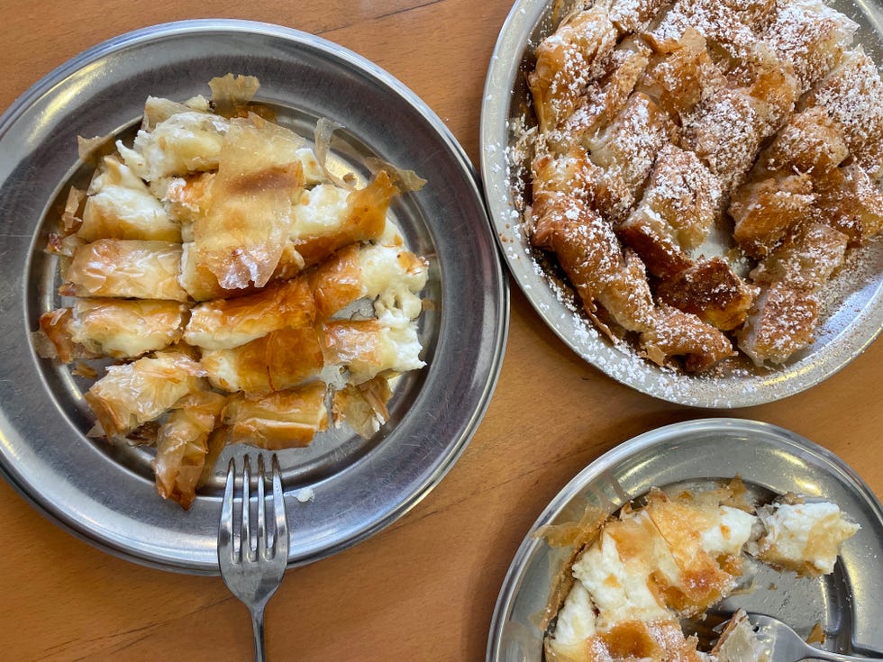 plates of baked pastry filled with cheese and sprinkled with powdered sugar