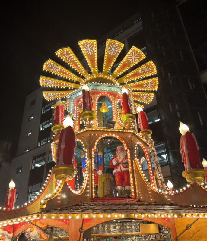 a lighted structure with a santa claus on top