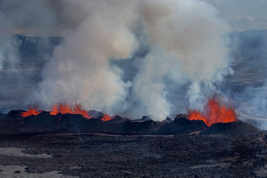 Holuhraun lava field eruption in Iceland Highlands with glowing magma and thick volcanic smoke.