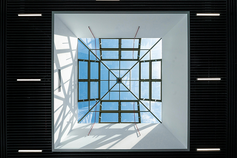 semi-transparent yellow metal arches frame airport’s terminal extension in romania