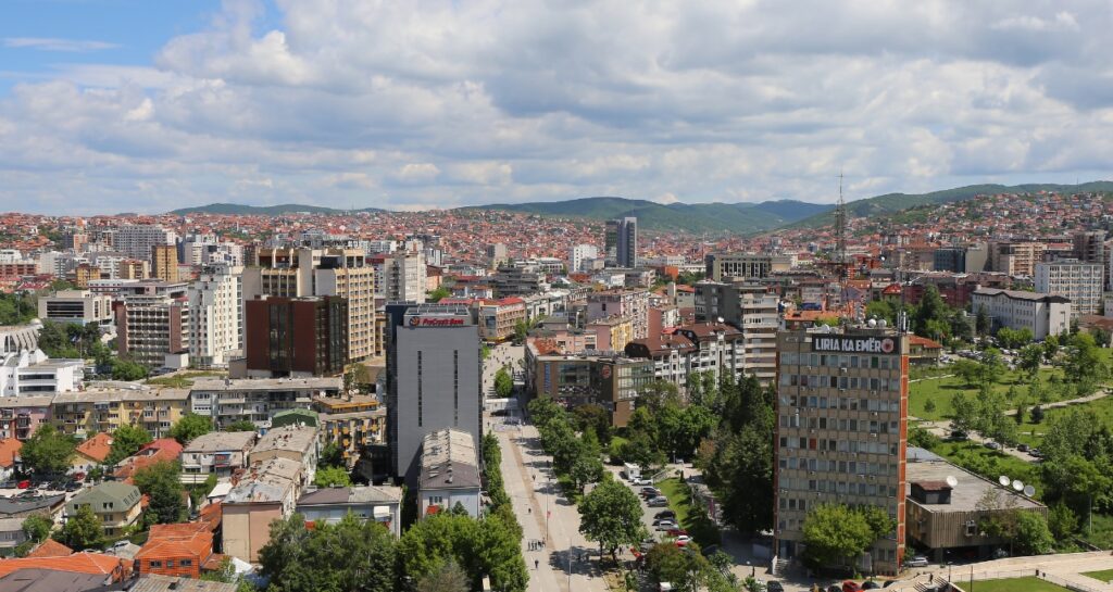 Aerial view with walking people, stores, cars and buildings in Pristina, Kosovo