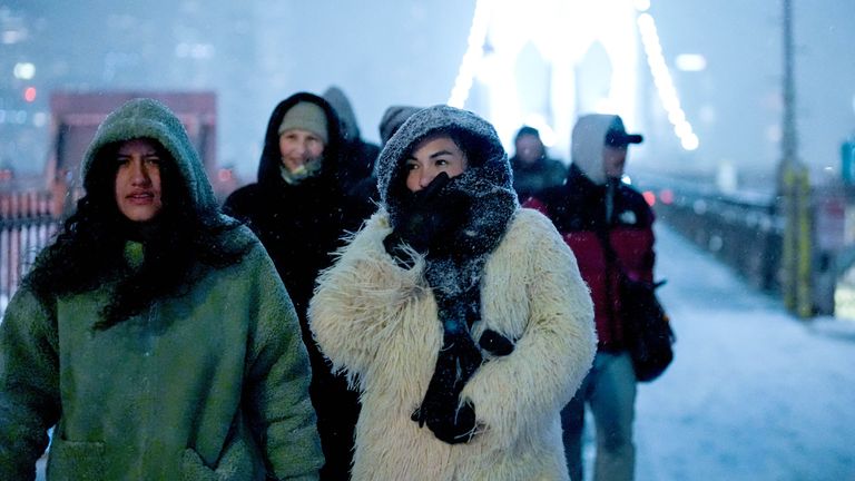 People walk across the Brooklyn Bridge. Pic: Reuters