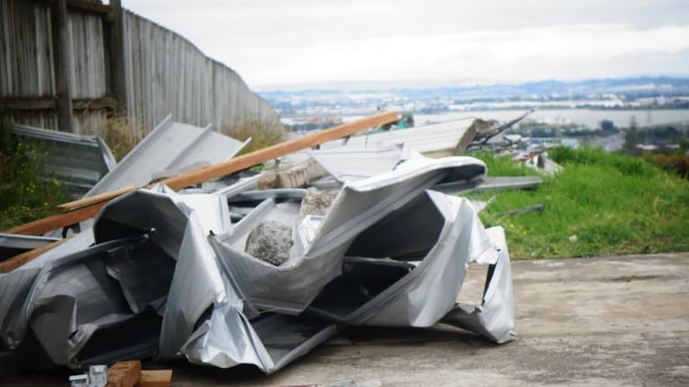 The roof of an unoccupied home in the Auckland suburb of Hillsborough came off in high winds and scattered debris down the road. Photo: RNZ / Kim Baker Wilson