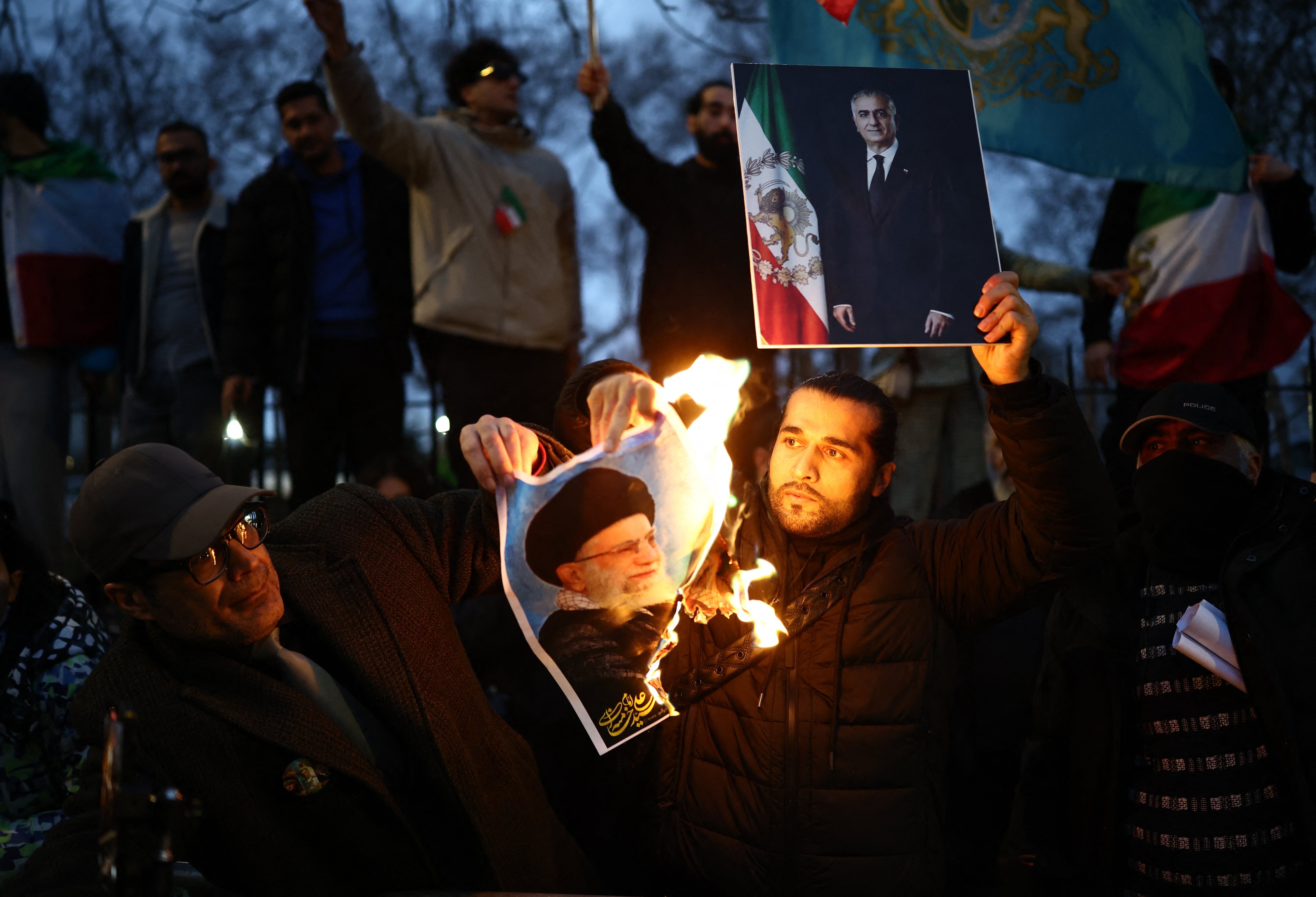 Anti-Iranian regime protesters burn an image of Ayatollah Ali Khamenei outside the embassy on Monday