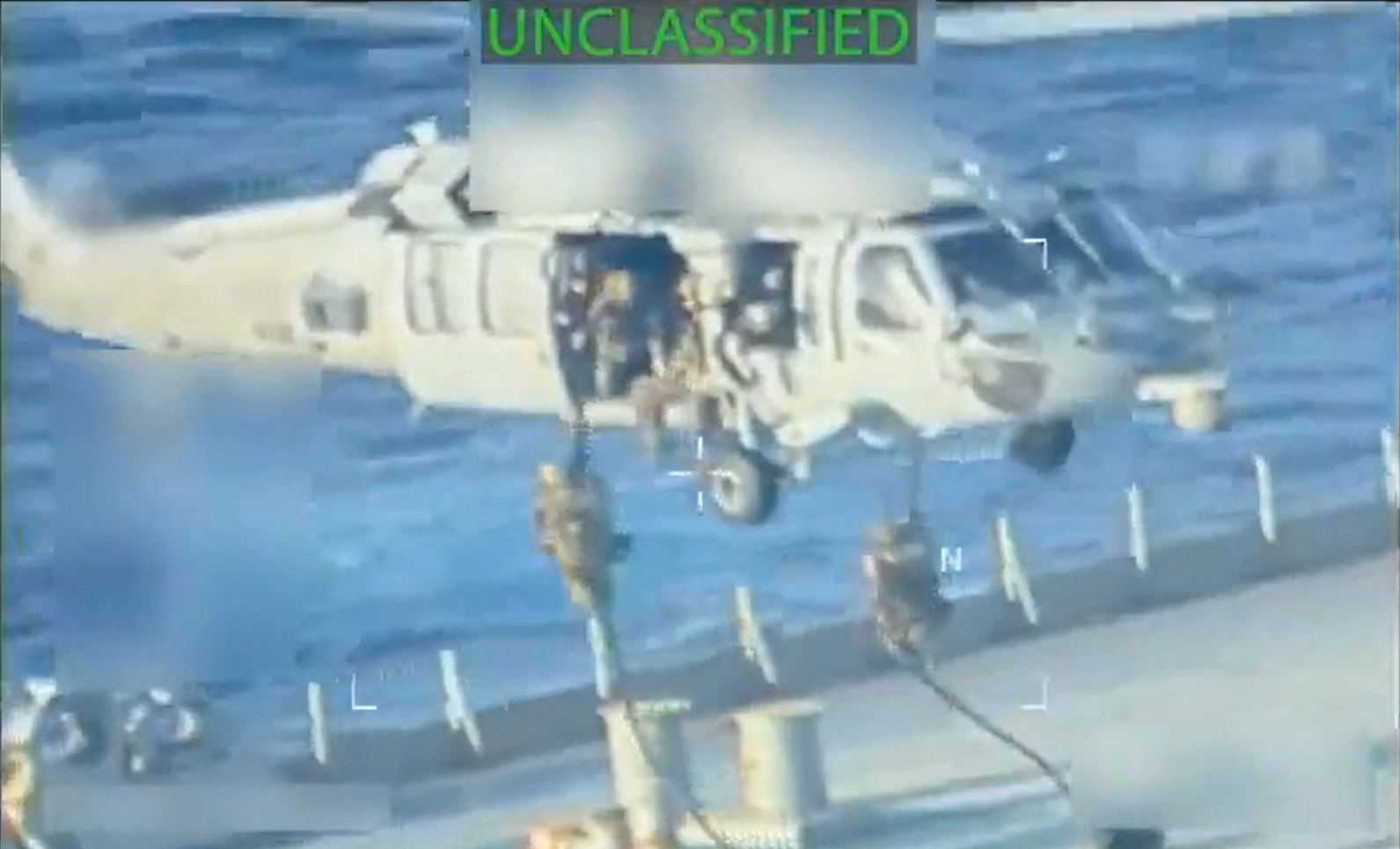 Screen grab from a video shows military personnel rappelling from a helicopter onto a tanker.