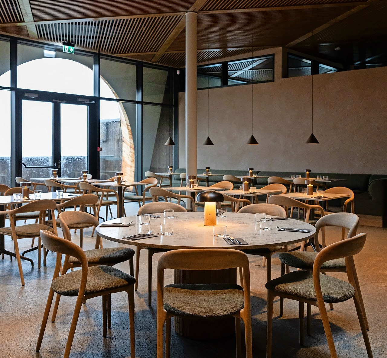 Interior of Laugarás Lagoon restaurant with set tables and chairs.