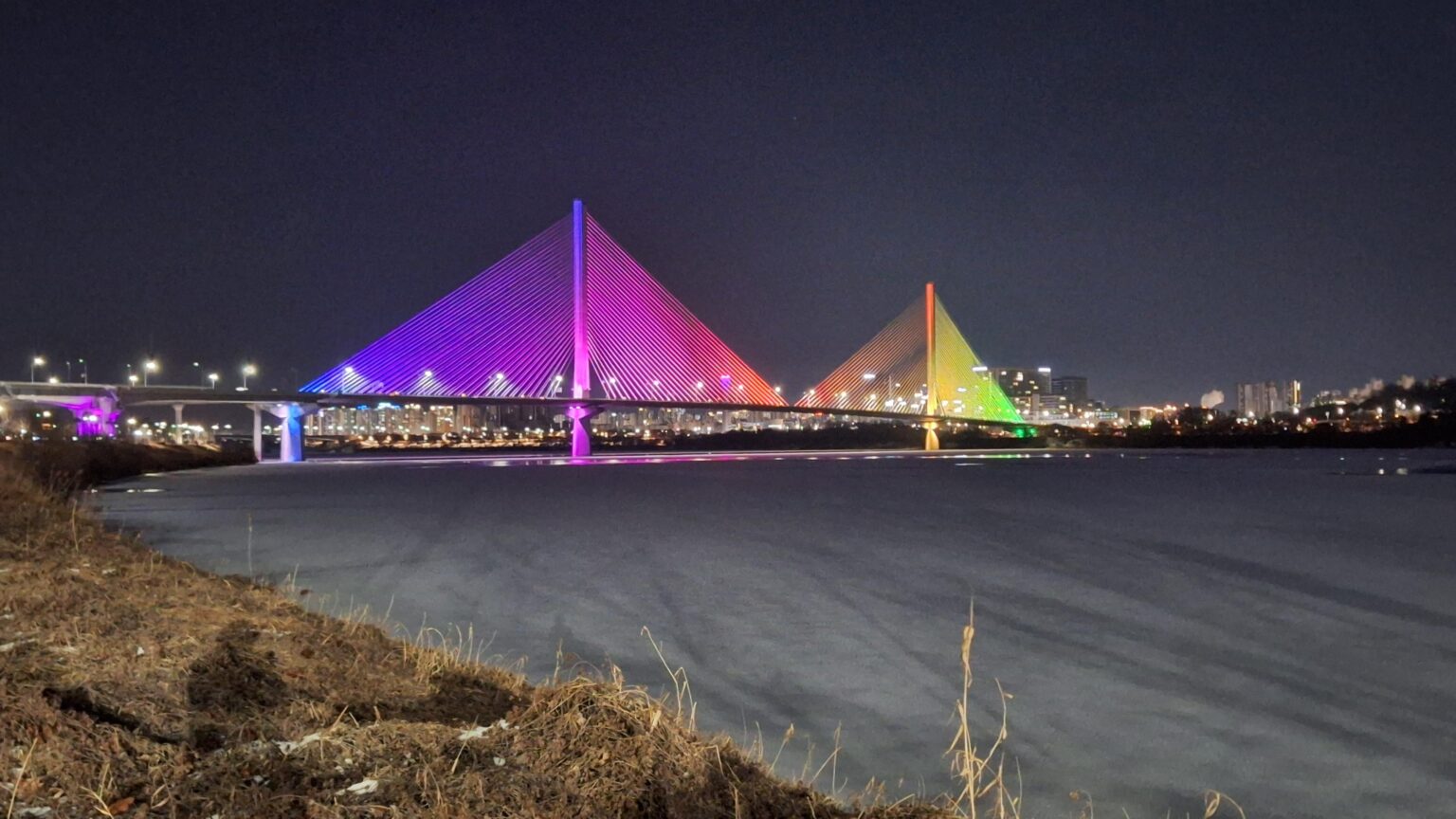 Snow-covered Han River under a rainbow bridge