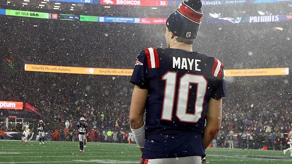 Drake Maye stands with his back to the camera at Gillette Stadium