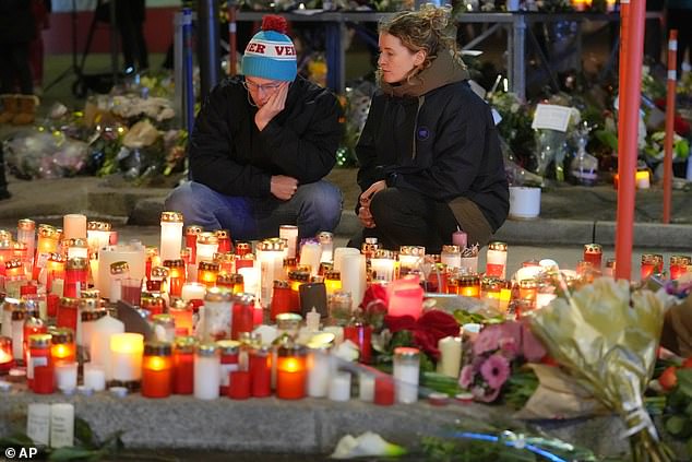 Mourners look at tributes to the victims of the Swiss nightclub fire