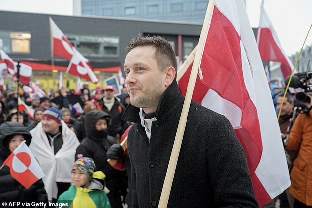 Greenland's Head of Government (Naalakkersuisut) Jens-Frederik Nielsen, holds his country's flag as he took part in a demonstration outside the US consulate in Nuuk on Saturday