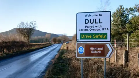 Vienna Tourist Board/Martin Morscher A road sign reading "Welcome to Dull. Paired with Boring, Oregon, USA"