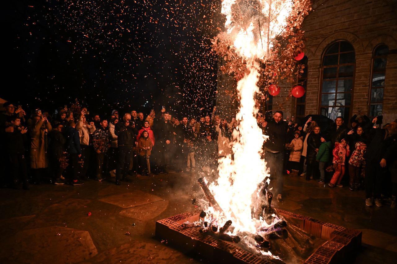 Kosovo Serbs gather around a bonfire during the ceremonial burning of dried oak branches, symbolizing the Yule log, at the monastery in Gracanica on January 6, 2026. (AFP Photo)