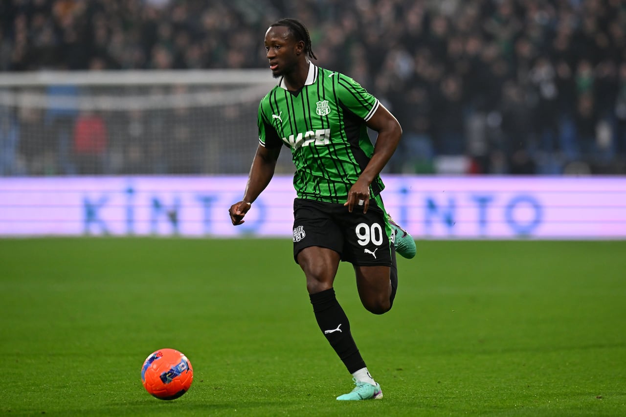 A soccer player runs with the ball.