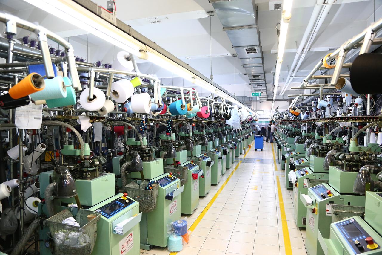 A textile factory operates rows of automated knitting machines in Türkiye. (Adobe Stock Photo)